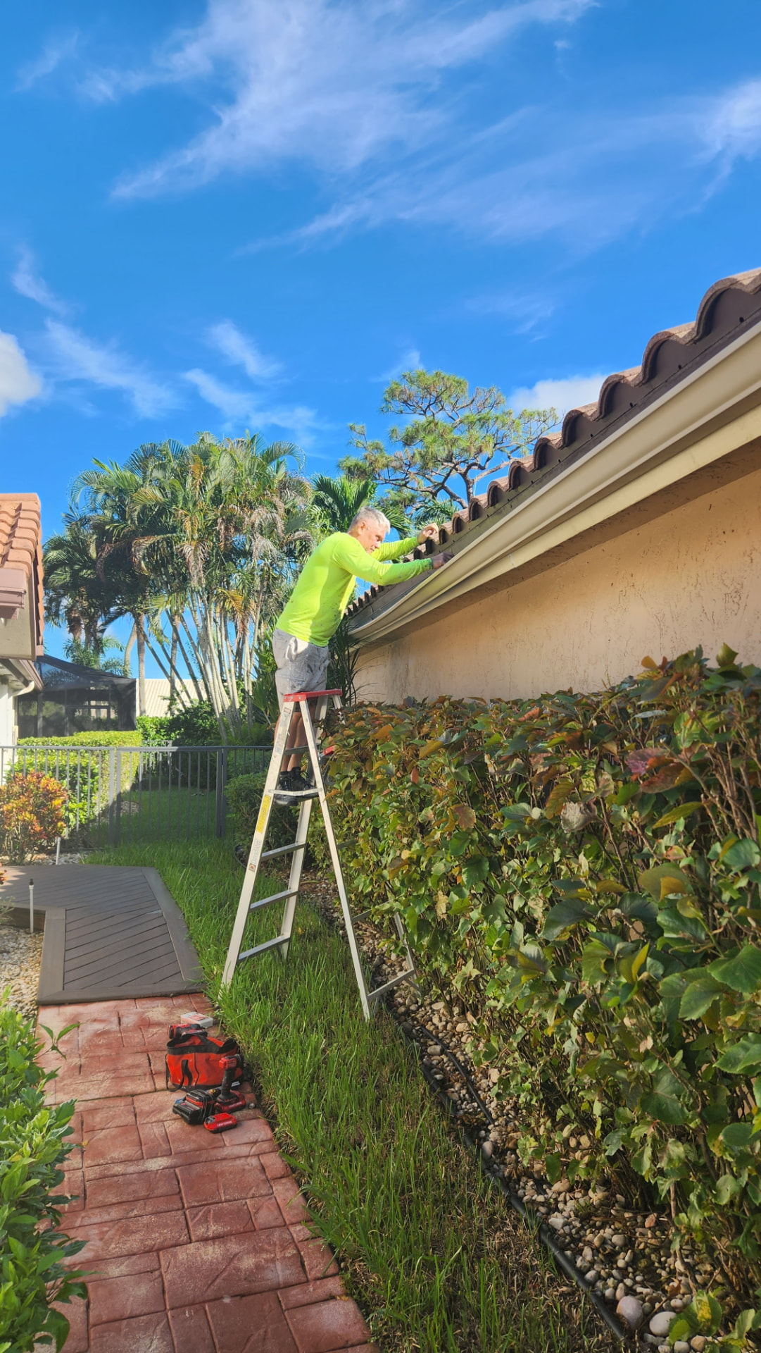 DeSoto Painting crew member painting gutters along a roofline
